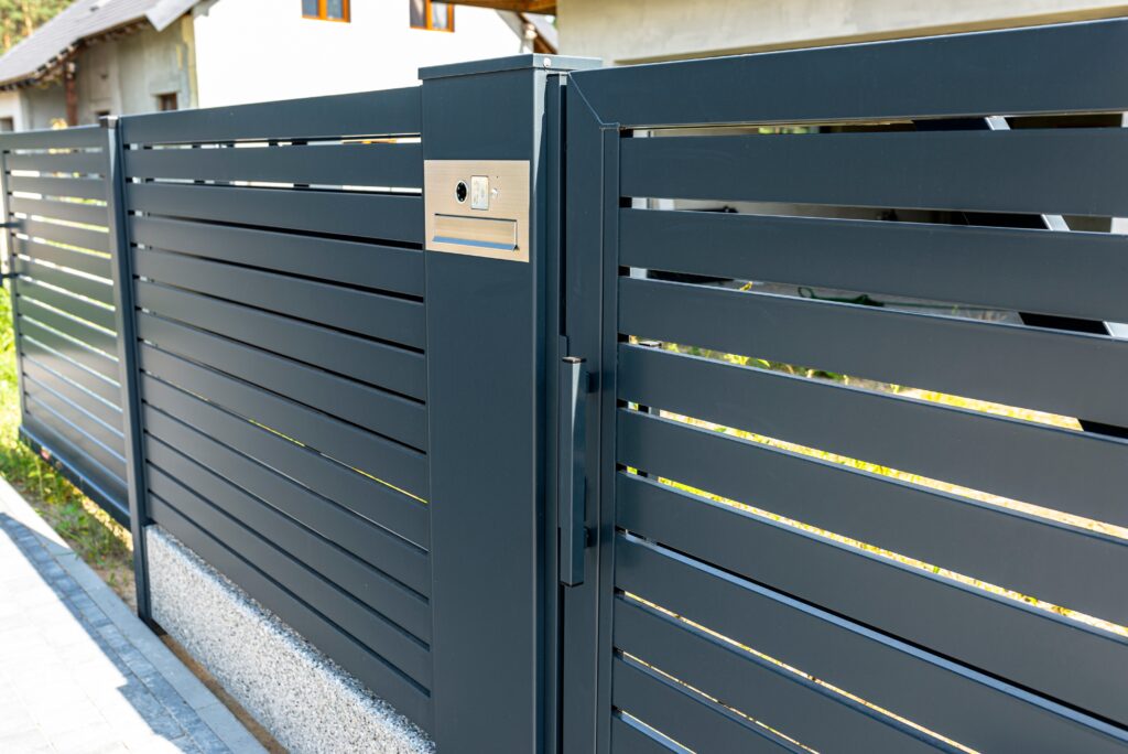 a modern videophone with a letterbox and a wireless card reader, mounted in panel fence in anthracite color, visible wicket.