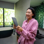middle eastern, asian woman managing her online banking, social life, and tasks on a digital tablet