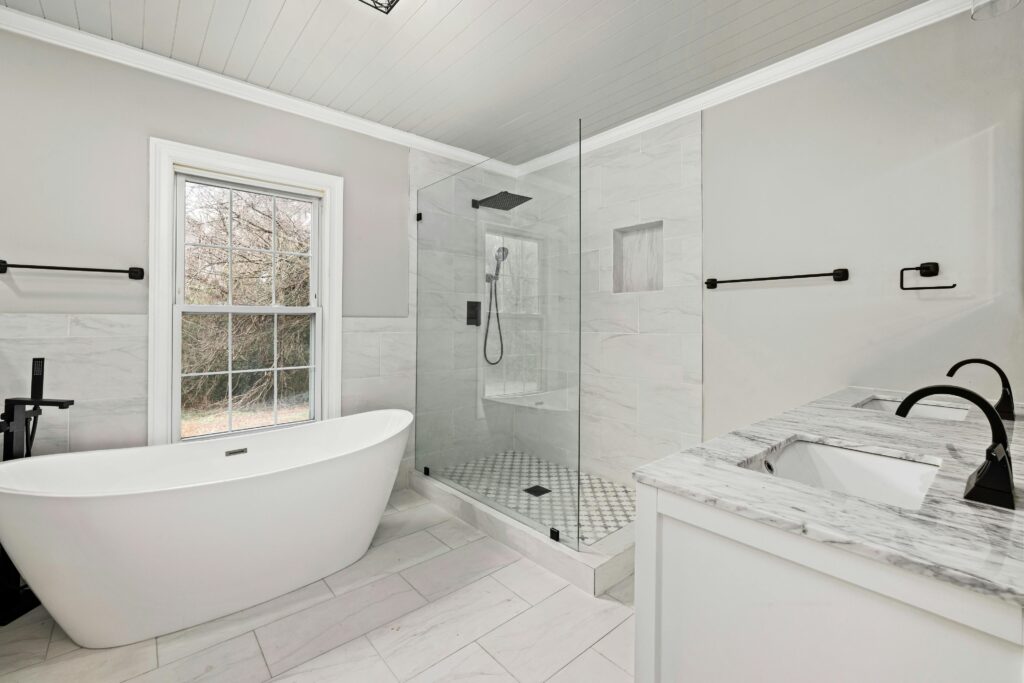 Sleek bathroom featuring a freestanding tub, glass shower, and marble accents.